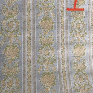 May include: A vintage wallpaper with a repeating pattern of floral motifs in shades of green and beige on a light gray background.