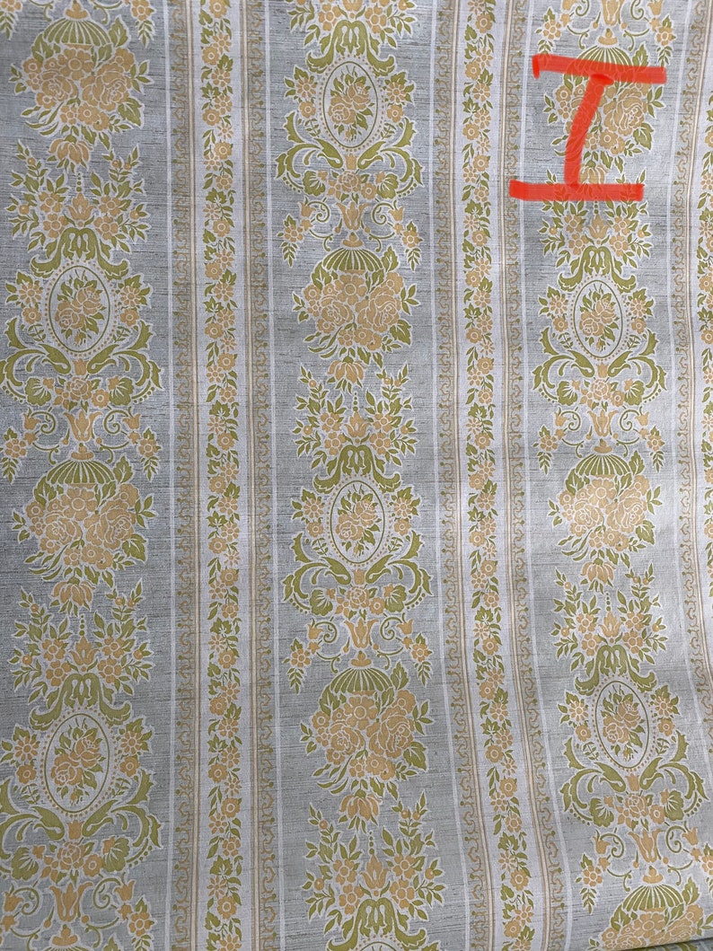 May include: A vintage wallpaper with a repeating pattern of floral motifs in shades of green and beige on a light gray background.