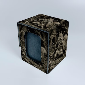 Könnte beinhalten: Eine schwarz-graue, rechteckige Kartenbox mit einer detaillierten Illustration eines Eichhörnchen-Kriegers, der ein Schwert und einen Schild hält. Das Motiv zeigt das Eichhörnchen in einem Wald mit Bäumen und einem kleinen Bau sowie ein schwarzes Sichtfenster.