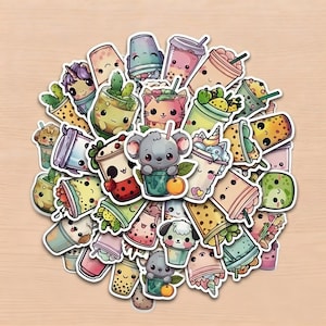May include: A collection of die-cut stickers featuring various bubble tea cups with cute animal faces, including a koala, cat, and unicorn, alongside fruit and plant elements in pastel colours, arranged in a circular cluster on a light wood surface.