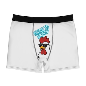 Puede incluir: Calzoncillos tipo bóxer blancos con una cinturilla negra y un gráfico central de un pollo blanco con gafas de sol negras. Sobre el pollo, el texto "COME TO DADDY" aparece en una fuente azul claro con estilo de burbuja en el panel frontal.