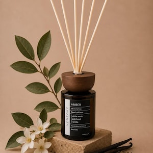 May include: A dark amber glass reed diffuser bottle with a dark wooden cap and six light-coloured reeds. The label reads VENTORE, AMBER, 100 ml / 3.4 fl.oz, Reed diffuser, white musk, patchouli, vanilla, Handcrafted in Oxford, Batch 001.