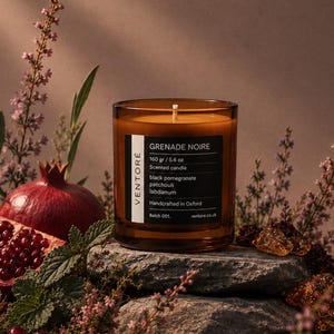 May include: A scented candle in a brown glass jar with a black label reading GRENADE NOIRE, 160 gr / 5.6 oz, black pomegranate, patchouli, labdanum, Handcrafted in Oxford, Batch 001, and ventore.co.uk, sitting on a gray stone surface.