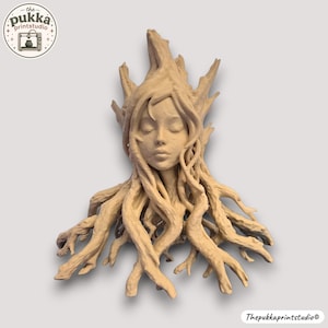 May include: A light tan, monochromatic sculpture of a human face emerging from intertwined tree roots and branches. The figure has closed eyes and a serene expression, with textured, gnarled wooden forms extending upwards and outwards.