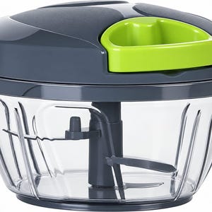 May include: A manual food chopper with a clear plastic bowl and a dark gray lid featuring a bright lime green pull handle. Inside the bowl is a dark gray central post with two sharp metal blades attached for chopping vegetables and other food items.