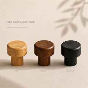 May include: Three solid wood cabinet knobs with a cylindrical design. The left knob is light oak, the center knob is dark walnut, and the right knob is black oak. Text on the image reads: SOLID WOOD CABINET KNOB, OAK, WALNUT, OAK BLACK.