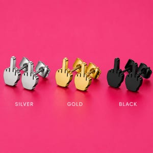 May include: Three pairs of stud earrings shaped like a hand making a middle finger gesture. The sets are finished in silver, gold, and black metal tones. Each earring features a post back closure. The words SILVER, GOLD, and BLACK are printed below.
