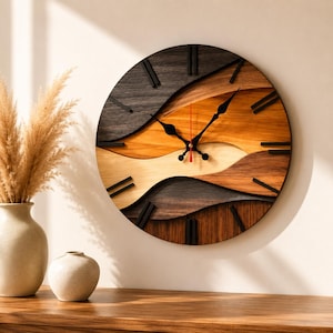 Puede incluir: Un reloj de pared circular con segmentos de madera superpuestos en varios tonos de marrón oscuro, medio y claro. La esfera tiene marcadores de hora negros, manecillas negras y un segundero rojo fino, formando un patrón de ondas.