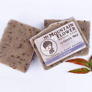 May include: Three bars of handmade lavender soap with goat's milk. The soap is labeled "My Mountain Flower Natural Soap with Goat's Milk Handmade in Small Batches Lavender".
