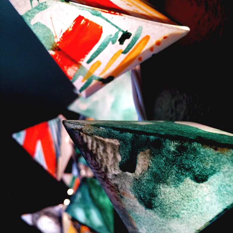May include: Abstract art made of paper triangles with watercolor paint in shades of red, orange, yellow, green, and blue.