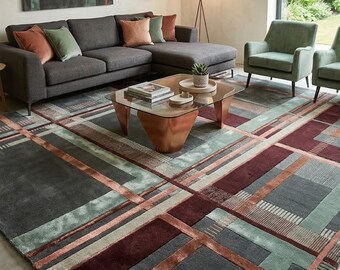 May include: A large area rug featuring a geometric pattern of intersecting lines and rectangular blocks in shades of charcoal gray, muted sage green, and deep burgundy. The design incorporates varied textures and color-blocked sections.