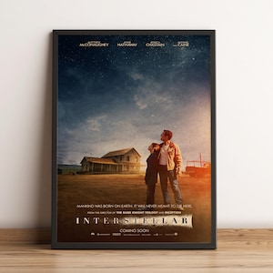 May include: A framed film poster for Interstellar showing a dark, starry sky over a rural farmhouse. Two figures stand in a dusty field looking upwards. The text reads: MANKIND WAS BORN ON EARTH. IT WAS NEVER MEANT TO DIE HERE. INTERSTELLAR.