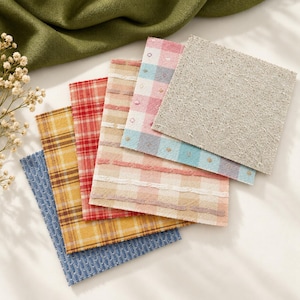 May include: A collection of six square fabric swatches featuring various patterns and textures. The swatches include blue, yellow, and red plaid designs, a pink and blue gingham check with small embroidered details, and a solid beige linen.
