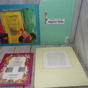 May include: Four children's books with colorful covers. The first book has a blue cover with a picture of a door and three children. The second book has a green cover with the text "I Can Read It All By Myself Beginner Books". The third book has a purple cover with the text "Classical Fairy Tales of Alice in Wonderland". The fourth book has a yellow cover with text about the book.