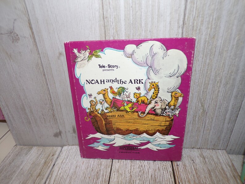 May include: A pink book cover with the title "Tele-Story presents NOAH and the ARK" in white text. The cover features an illustration of Noah's Ark with animals on board, including a camel, giraffe, elephant, and birds. The text "SUPERSCOPE PRODUCTION" is printed in white at the bottom of the cover.