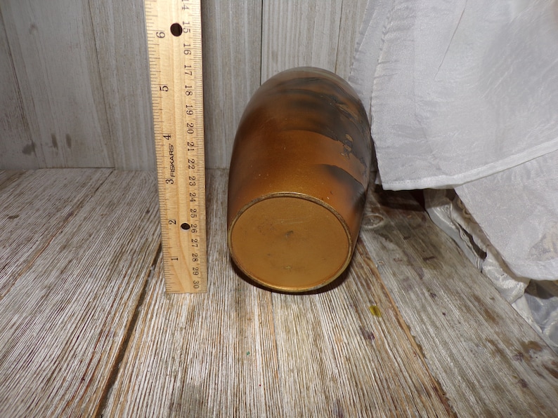 May include: A brown ceramic vase with a textured surface and a gold-colored base. The vase is approximately 6 inches tall.