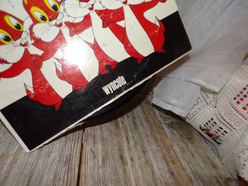 Puede incluir: Una portada de disco de vinilo en blanco y negro con una imagen de dibujos animados de cinco ardillas rojas. La portada del disco tiene el texto "Wyncote" impreso en la esquina inferior derecha.