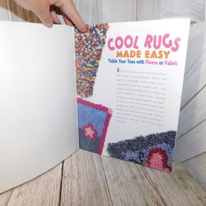 May include: A book titled "Cool Rugs Made Easy" with a pink, blue, and red rug design on the cover. The book's subtitle is "Tickle Your Toes with Fleece or Fabric".