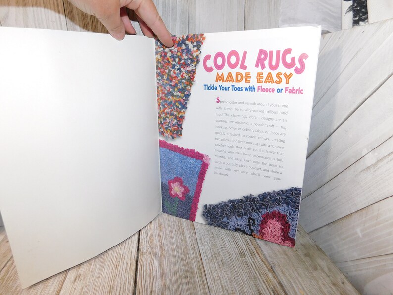 May include: A book titled "Cool Rugs Made Easy" with a pink, blue, and red rug design on the cover. The book's subtitle is "Tickle Your Toes with Fleece or Fabric".