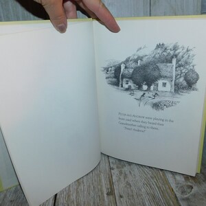 May include: A black and white illustration of a cottage with a thatched roof, surrounded by trees and a stone wall. The text "PETER AND ANDREW were playing in the thone yond when they heard thes Candmother calling to them. Prel Andew" is printed below the illustration.