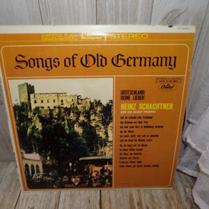 May include: A vintage vinyl record album cover featuring a photo of a castle in the German countryside. The album title is "Songs of Old Germany" and the artist is Heinz Schachtner and His Silver Trumpet. The album is a Capitol Records release.
