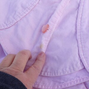 Puede incluir: Una chaqueta de pana rosa con cierre de bot&oacute;n. La chaqueta tiene un estilo ligeramente recortado y un cuello.