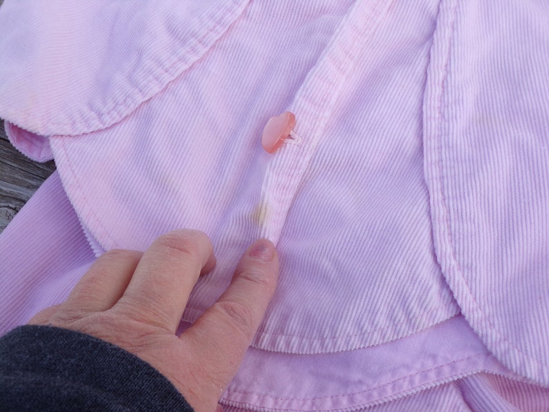 Puede incluir: Una chaqueta de pana rosa con cierre de bot&oacute;n. La chaqueta tiene un estilo ligeramente recortado y un cuello.
