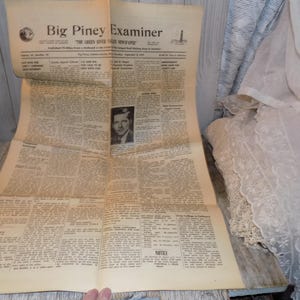 May include: A vintage newspaper, the Big Piney Examiner, dated September 12, 1957. The headline reads "The Green River Valley Newspaper". The newspaper is folded in half and shows a black and white photo of a man.