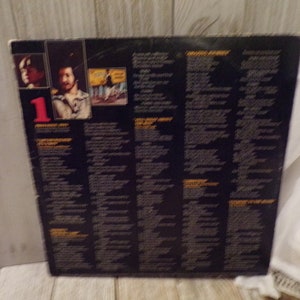 May include: Black vinyl record album cover with a photo of a man with a beard and a hat. The album title is "The Best of the Doobie Brothers" and the album number is "1". The back of the album cover has the lyrics to the songs on the album.