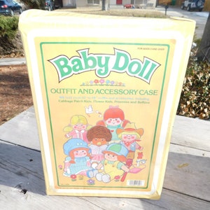 May include: A vintage yellow Baby Doll Outfit and Accessory Case. The case features a green and yellow label with the words "Baby Doll" and "Outfit and Accessory Case". The label also includes illustrations of several dolls. The case is designed to hold 16" to 18" outfits and accessories.