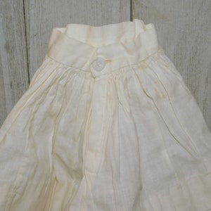 May include: A white cotton garment with a gathered skirt and a button fastening at the neck.