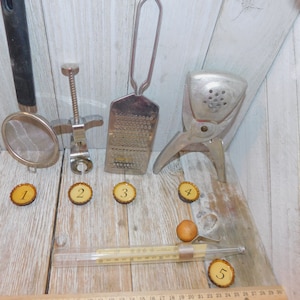 May include: Five kitchen tools, including a grater, a citrus juicer, a bottle opener, a strainer, and a thermometer, are arranged on a wooden surface. Each tool is labeled with a number from 1 to 5.