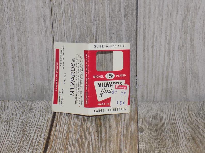 Pode incluir: Uma embalagem de cart&atilde;o branco com texto vermelho e preto para agulhas de olho grande Milwards Need 97. A embalagem diz "N&iacute;quel 15c  Prata" e "25 Betweens 5/10".