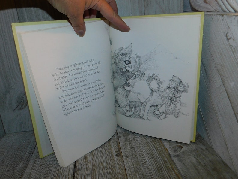 May include: A black and white illustration of a man with a basket on his back. A creature with a long snout and large ears is reaching into the basket with its hand. The man is looking down at the creature. The text in the image reads: "I'm going to lighten your load a little," he said. "I'm going to relieve you of that basket." He shoved one pistol back into his belt and proceeded to unite the basket with his free hand.