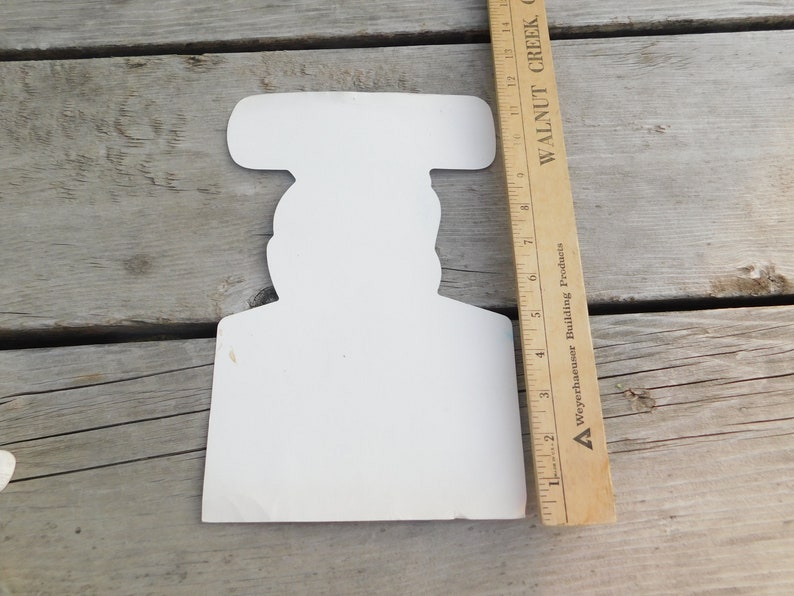Peut inclure: D&eacute;coupe en carton blanc d'une personne portant un chapeau. La d&eacute;coupe mesure environ 18 cm de haut.