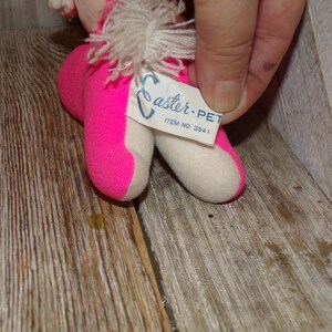 May include: Pink and white Easter-themed plush toy with a white fluffy tail. The toy has a tag that reads "Easter-Pet Item No. 3541".