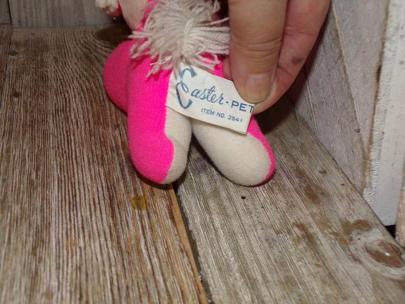 May include: Pink and white Easter-themed plush toy with a white fluffy tail. The toy has a tag that reads "Easter-Pet Item No. 3541".