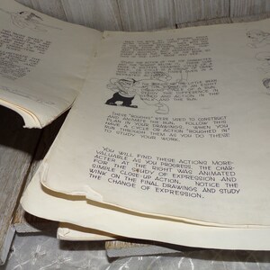 May include: Vintage animation guide with detailed instructions and illustrations. The pages show step-by-step drawings of a cartoon character in motion, with handwritten notes and diagrams. The guide is designed to teach animation techniques.
