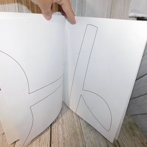 May include: An open book with blank pages and a black line drawing of a shape on each page. The book has a blue and white title on the spine that reads "BIG IDEAS".