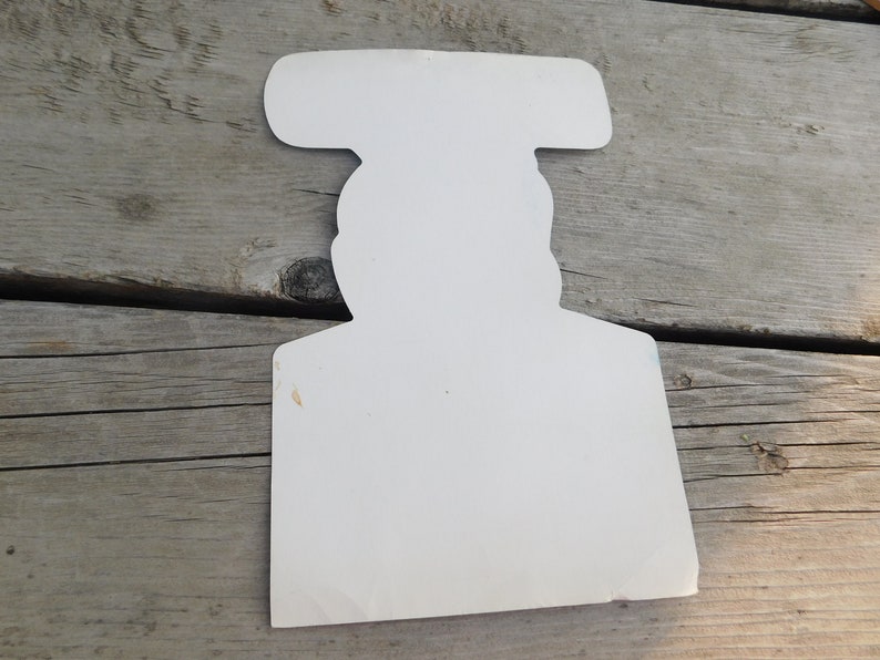 Peut inclure: D&eacute;coupe en carton blanc d'une personne portant un chapeau. La d&eacute;coupe est vide et a un design simple.