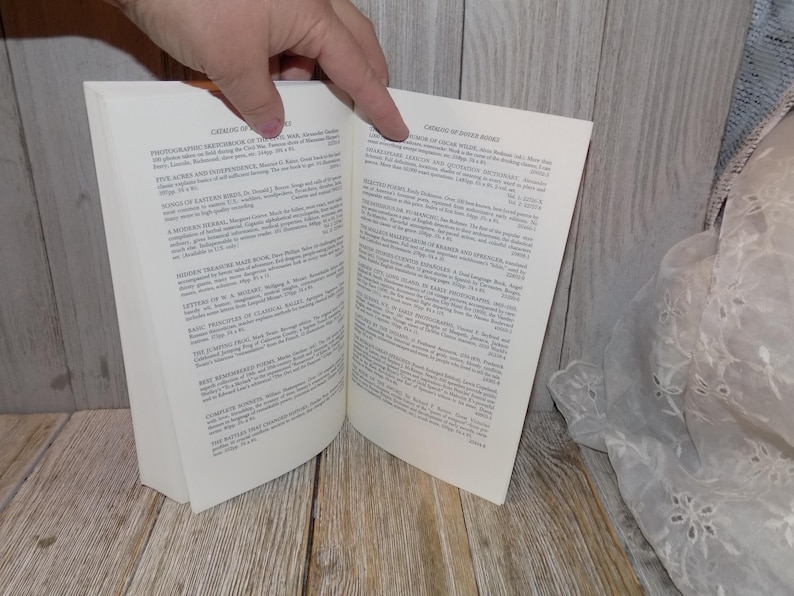 May include: Open book with a white cover and black text. The book is titled "Catalog of Editions" and lists various books and their authors. The right page of the book is titled "Crown of Thorns Breed" and lists various books and their authors.