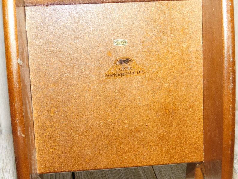 Puede incluir: Una caja de madera marr&oacute;n con una etiqueta que dice "&copy;1990 Heritage Mint Ltd."