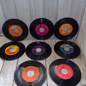 May include: Eight vintage 45 rpm vinyl records with different labels and artists. The labels include Parkway, Coral, Columbia, and others. The records are black with colorful labels.