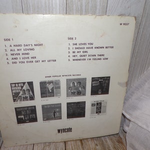 Puede incluir: Una portada de &aacute;lbum de vinilo blanco con texto negro. El &aacute;lbum se titula "The Beatles" y presenta los t&iacute;tulos de las canciones "A Hard Day's Night", "All My Loving", "Never Mind", "And I Love Her", "Did You Ever Get My Letter", "She Loves You", "I Should Have Known Better", "Be My Girl", "Hey, Quiet Down There" y "Whenever I'm Feeling Low".
