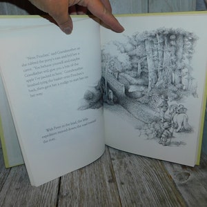 May include: A black and white illustration of a group of people and a horse walking down a path through a forest. The text "Now, Peaches," "said Grandmother as she rubbed the pony's ear and fed her a carrot." "You behave yourself and maybe Grandfather will give you a bite of the apple I've packed in here." Grandmother finished tying the basket onto Peaches's back, then gave her a nudge to start her on her way." and "With Peter in the lead, the little expedition moved down the road toward the river." is visible in the image.