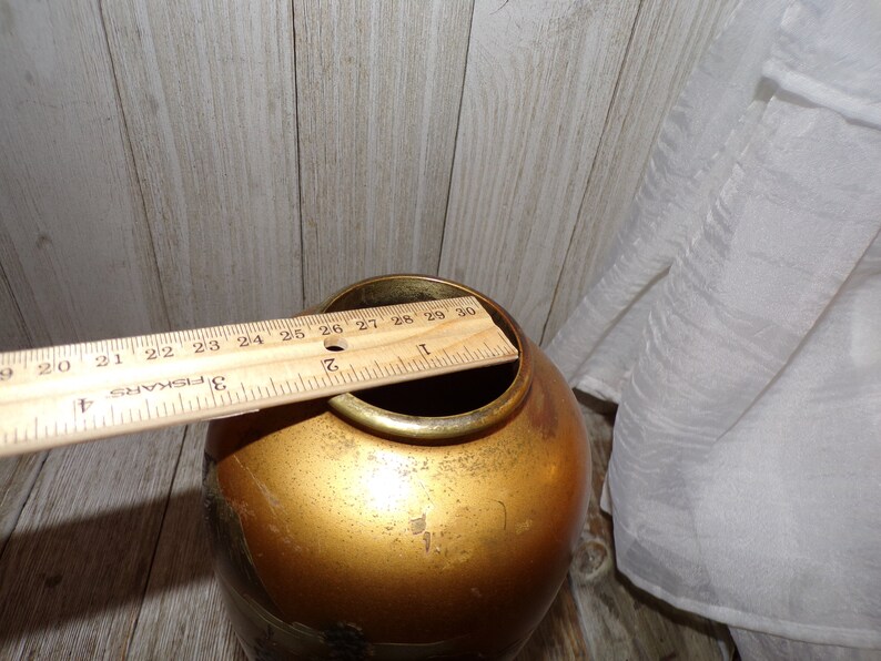 May include: A gold-colored ceramic vase with a wide mouth and a rounded body. The vase is approximately 9 inches tall.