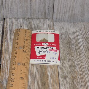 Pode incluir: Um pacote vermelho e branco de agulhas Milwards Need 97 de olho grande. O pacote &eacute; etiquetado com o pre&ccedil;o de 15 c&ecirc;ntimos e o tamanho 13. As agulhas s&atilde;o niqueladas.