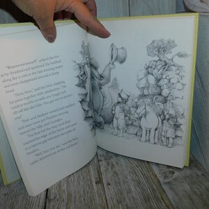 May include: A black and white illustration from a children's book showing a bear, a fox, two children, and a donkey. The bear is standing on a pile of rocks and is talking to the fox. The fox is swimming in a river. The children and the donkey are walking towards the bear. The text in the image reads: "Waaoooowwww!! yelped the fox as he thrashed and spunered. He bobbed along like a cork in the fast moving water and soon disappeared around a sharp bend."