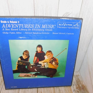 May include: A blue vinyl record album cover with the title "Adventures in Music" and a picture of three children playing music. The album is part of a series called "A New Record Library for Elementary Schools".