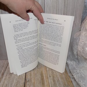 May include: An open book with a white background. The book is open to a page titled "The Old Man's Bundle" and a page titled "Games and Fun with Playing Cards". The text on the page describes the rules for a card game.